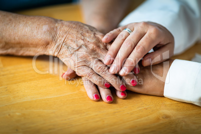 Younger Female Hands Holding Senior Adult Woman Hands