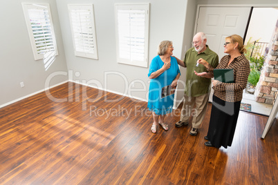 Female Real Estate Agent Handing New House Keys to Senior Adults