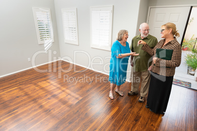 Female Real Estate Agent Handing New House Keys to Senior Adults