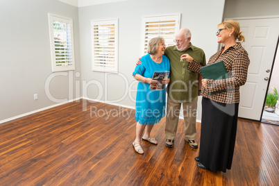 Female Real Estate Agent Handing New House Keys to Senior Adult