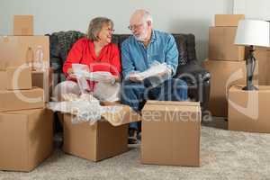 Senior Adult Couple Packing or Unpacking Moving Boxes