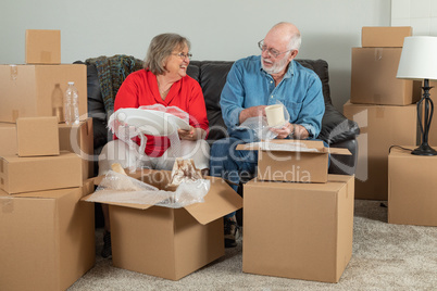 Senior Adult Couple Packing or Unpacking Moving Boxes