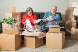 Senior Adult Couple Packing or Unpacking Moving Boxes