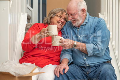 Tired Senior Adult Couple Resting on Stairs with Cups of Coffee