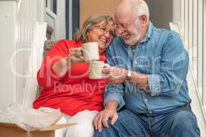 Tired Senior Adult Couple Resting on Stairs with Cups of Coffee