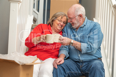 Tired Senior Adult Couple Resting on Stairs with Cups of Coffee