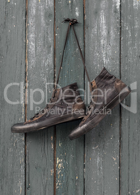 black textile classic sneakers hang on a rusty nail