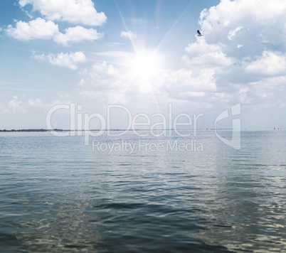 view of the sea with white fluffy clouds