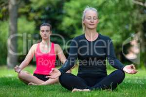 Mature Middle Aged and Young Woman Practicing Yoga Outside