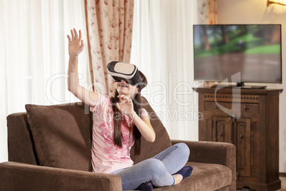 Teenager girl having fun with virtual reality glasses at home