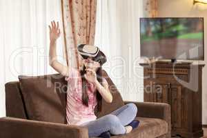 Teenager girl having fun with virtual reality glasses at home