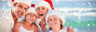 Composite image of family during christmas day at the beach