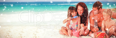 Composite image of portrait of a family at the beach