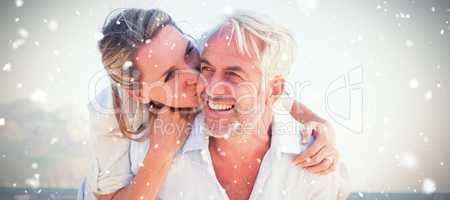 Composite image of man giving his smiling wife a piggy back at the beach