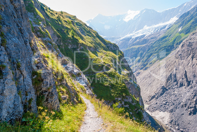 Hiking trail in the Swiss Alps in summer overlooking the Eastern slopes of the Eiger peak