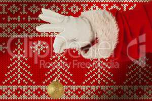 Composite image of santa claus holding christmas bauble