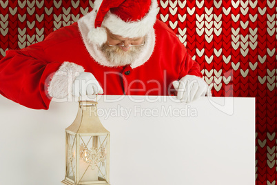 Composite image of santa claus holding christmas lantern on white board