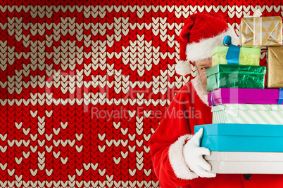 Composite image of santa claus hiding behind stack christmas gifts