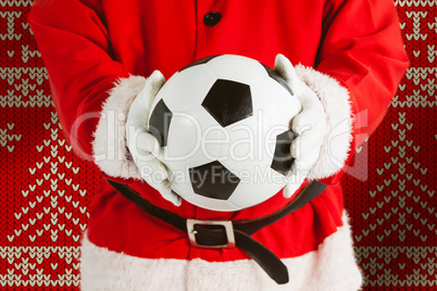 Composite image of santa claus holding a football