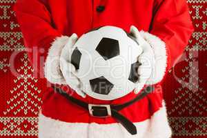 Composite image of santa claus holding a football