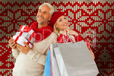 Composite image of happy festive couple with gifts and bags