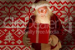 Composite image of father christmas opening a magical christmas gift