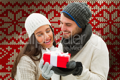 Composite image of winter couple holding gift