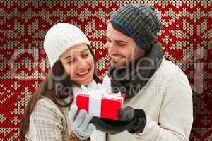 Composite image of winter couple holding gift