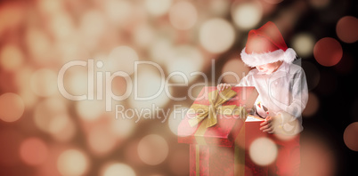 Composite image of festive boy opening gift