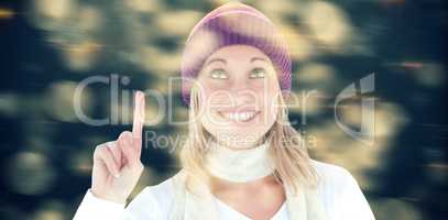 Composite image of bright woman with a colorful hat pointing upwards