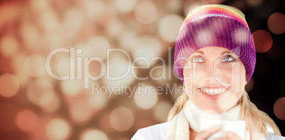 Composite image of smiling woman with a colorful hat and a cup in her hands