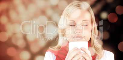 Composite image of portrait of a young woman enjoying her hot coffee in the winter