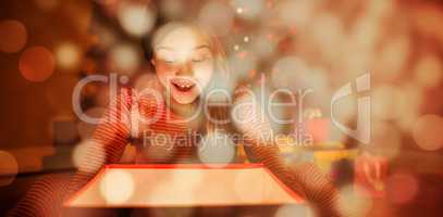 Composite image of little girl opening a glowing christmas gift