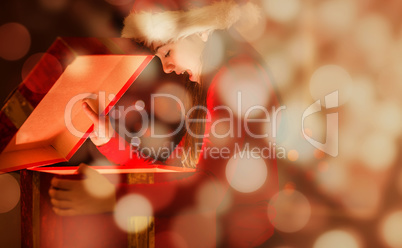 Composite image of festive little girl opening a glowing christmas gift