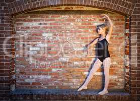 Cute Caucasian Ballerina Girl Posing Against A Brick Wall