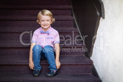 Cute Young Caucasian Boy Portrait Sitting On Stair Steps