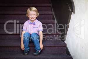 Cute Young Caucasian Boy Portrait Sitting On Stair Steps