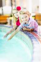 Cute Young Caucasian Brother and Sister Enjoying a Fountain At