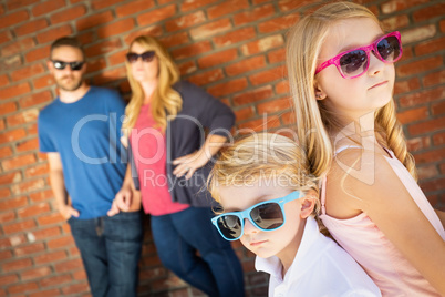 Cute Young Caucasian Brother And Sister Wearing Sunglasses with