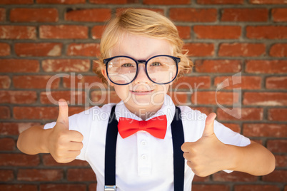 Cute Young Caucasian Boy With Thumbs Up Wearing Glasses and Red,