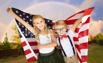 Cute Young Cuacasian Boy and Girl Holding American Flag With Rai