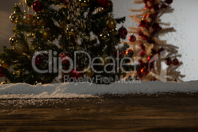 Wooden table with snow and Christmas tree