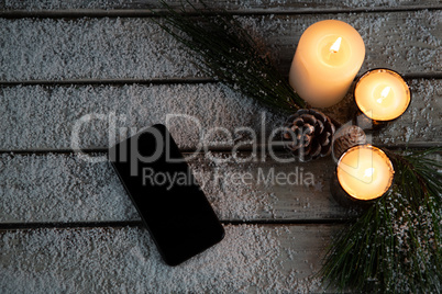 smartphone in the snow with candles