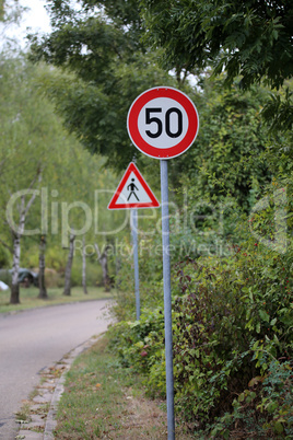 Round speed limit road sign on the road. 50 km per hour.
