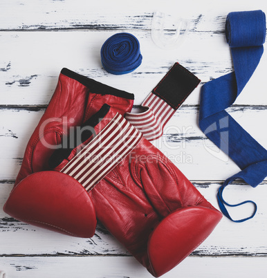 pair of leather red boxing gloves, blue bandage