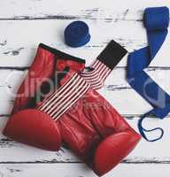 pair of leather red boxing gloves, blue bandage