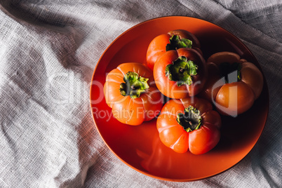 Some Persimmons on Orange Plate