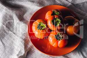 Some Persimmons on Orange Plate