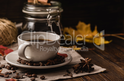 Cup of coffee with ingredients, spices and some kitchenware.