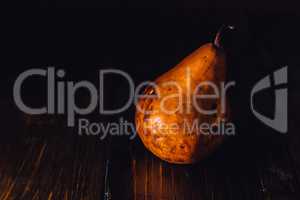 One Golden Pear on Wooden Background.